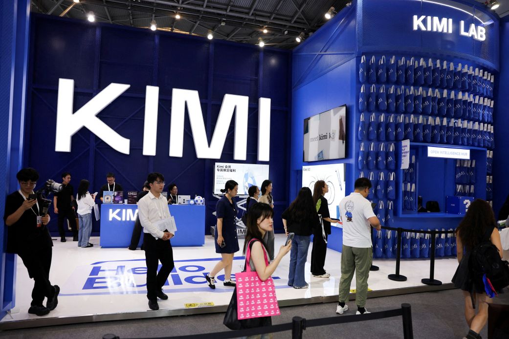 People walk past the Moonshot booth promoting its Kimi K3 AI model, during the World Artificial Intelligence Conference in Shanghai, China, July 17, 2026.