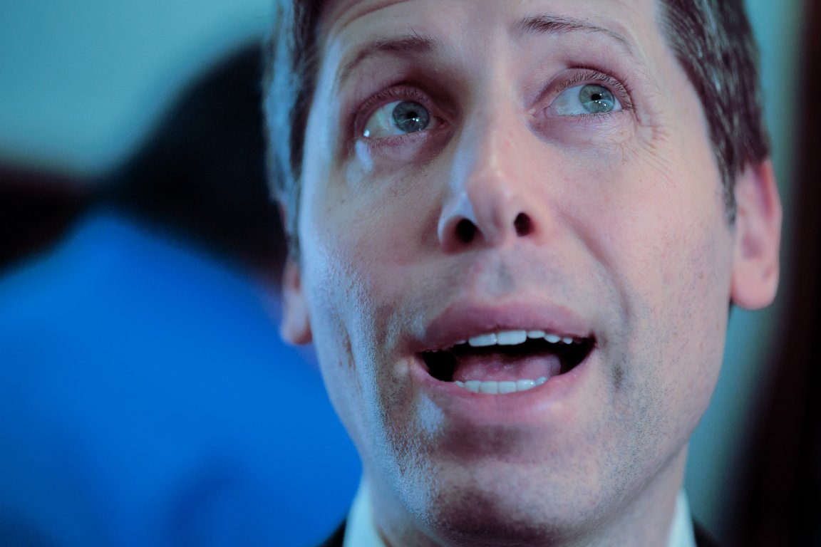 A close-up photograph OpenAI CEO Sam Altman as he fields questions from reporters.